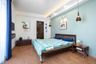 12x9 Ft Guest Room Design With Light Blue Accent Wall And Wooden Bed - Livspace