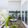 Tropical-style balcony with white walls, grey wall planters, and wooden flooring - Livspace