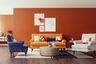 Tangerine orange wall paint contrasting with eclectic furniture for living rooms -Livspace