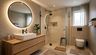 Modern Bathroom Design With Arched Mirror and Beige and Grey Tiles