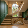 U-Shaped Marble Staircase Design with Patterned Tile Risers and Brass Railing