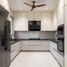 U-Shaped Kitchen Design with White Base Cabinets and Built-In Oven Unit