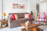 Dark Beige Sofa With Pink Patterned Cushions And Accent Chair - Livspace