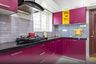 Dark Pink L-Shaped Kitchen Design With Granite Countertop And Yellow Open Storage - Livspace