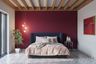 Red Bedroom Wall Paint Design With Wooden Rafter Ceiling Design - Livspace