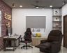 Industrial Home Office Design With Red Brick Accent Wall, White And Wood Study Table, Red And Black Swivel Chair, Wooden Storage Seater And Brown Recliner - Livspace