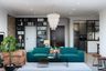 Living Room Design With Turquoise Sofa, Light Brown Leather Accent Chair, Black Open Bookshelf And Glass Coffee Table - Livspace