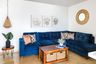 Living room with wall decor, blue sofa and drop light - Livspace